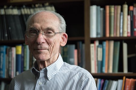 Dr. Stone in front of the bookshelf in his office