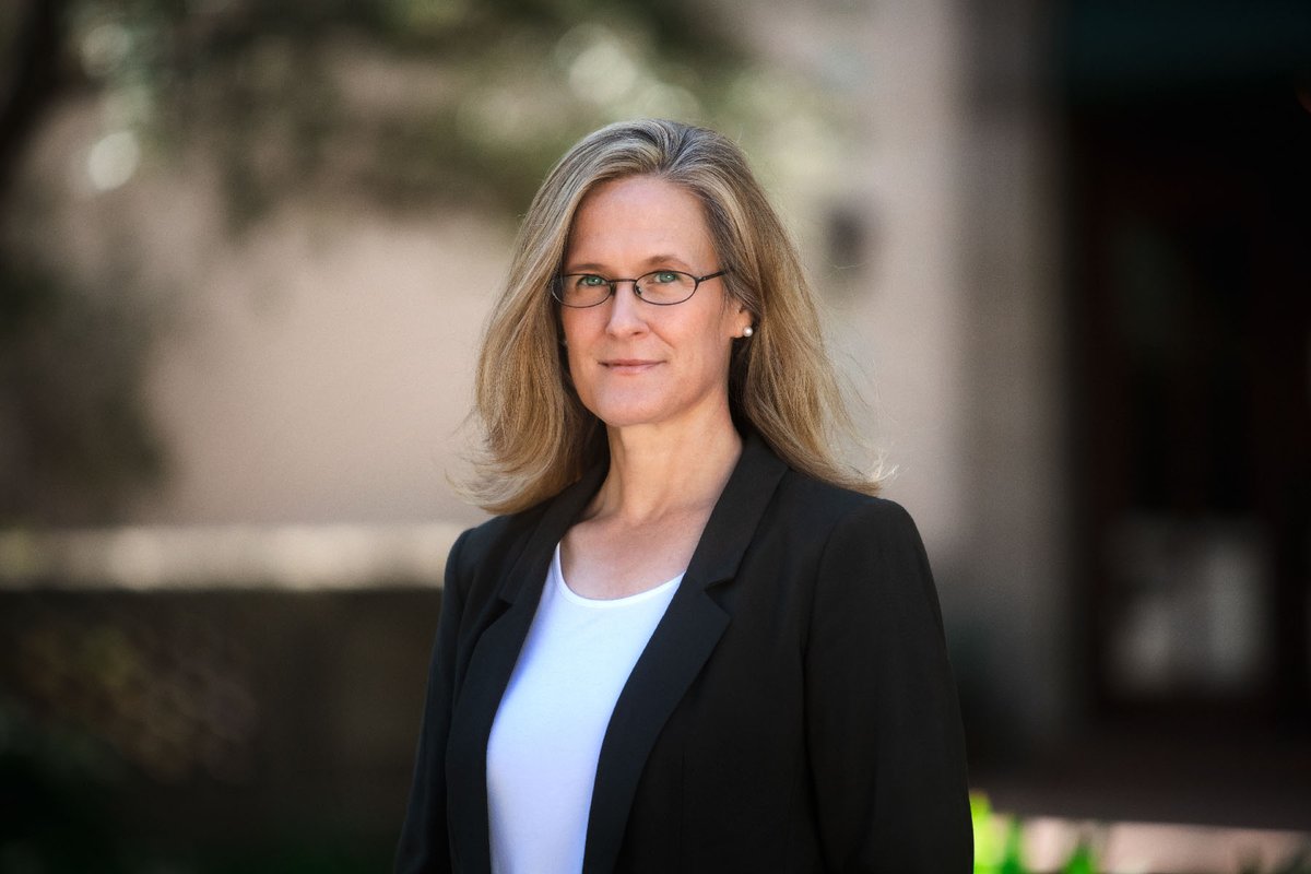 A portrait of Tracy Dennison. She is outside and wears a blazer.