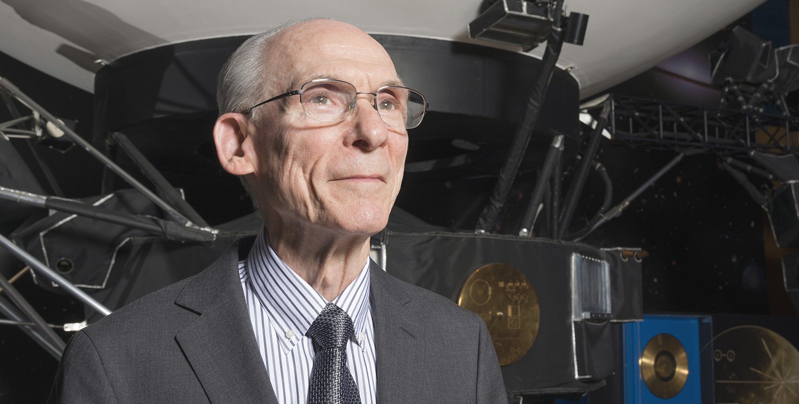 A man standing in front of a large model of a spacecraft