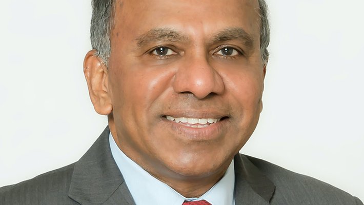A man in business attire looking into the camera