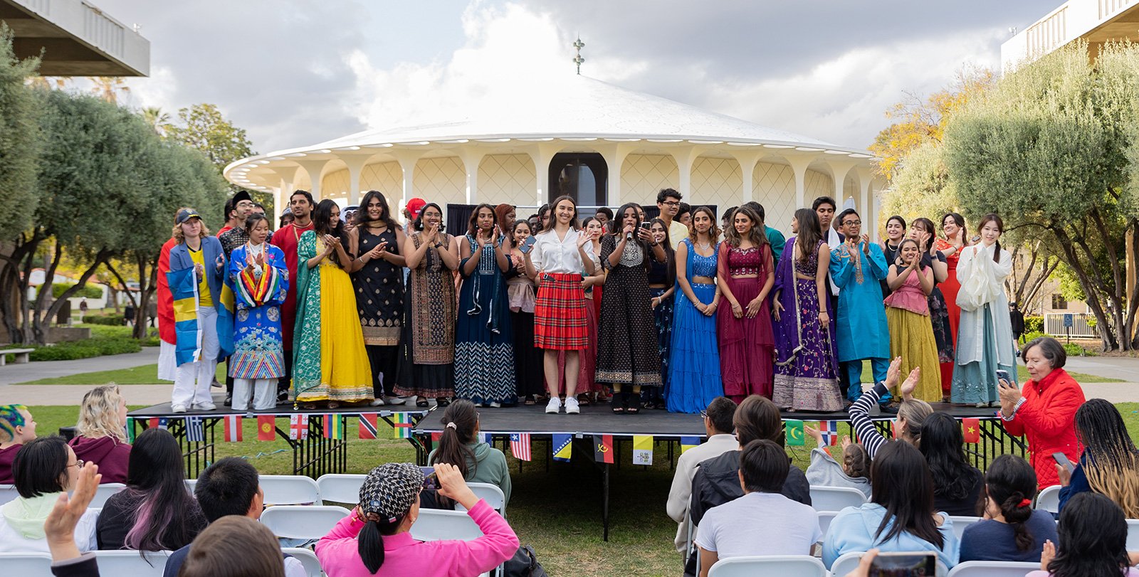 A group of students stands together on stage at World Fest